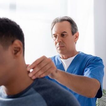 The doctor performs a diagnostic examination of a patient with neck pain. 